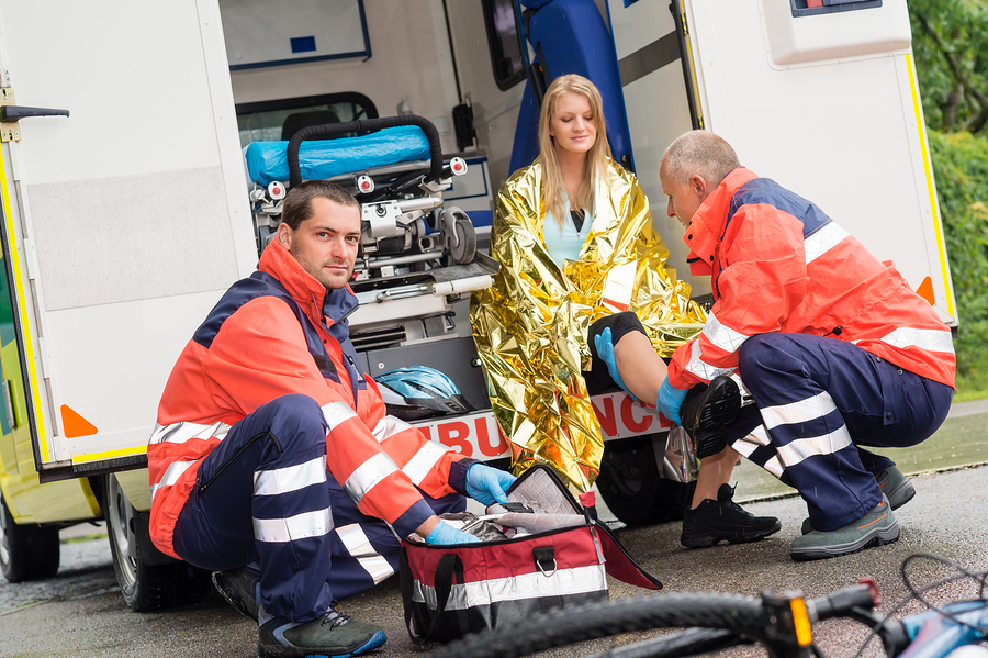 cyclist woman hit by a car and tended to by paramedics